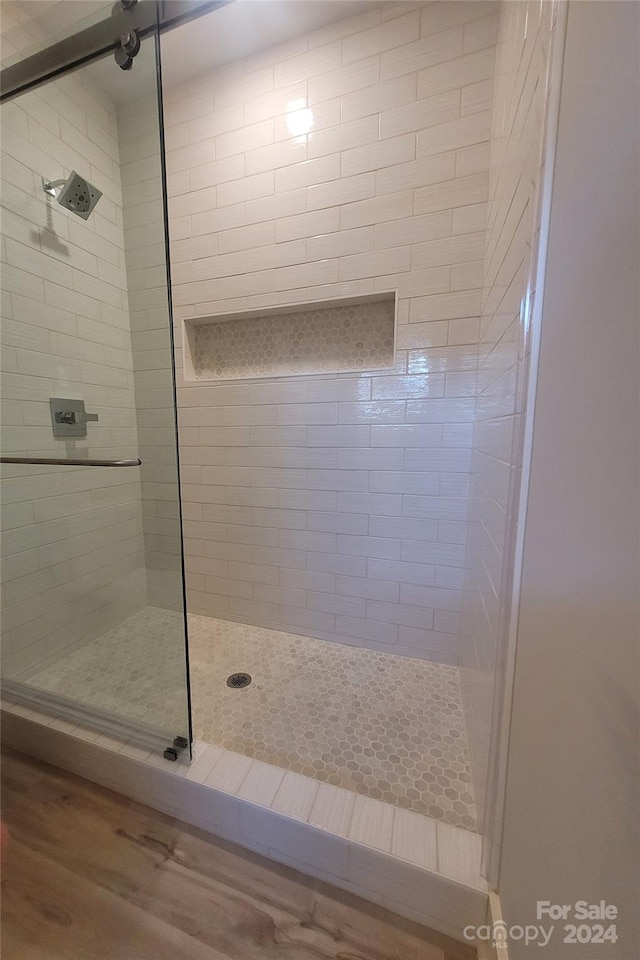 bathroom with an enclosed shower and hardwood / wood-style floors