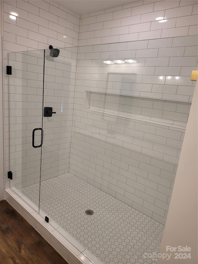 bathroom featuring an enclosed shower and wood-type flooring