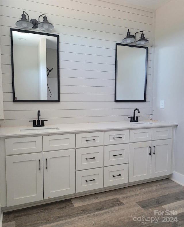 bathroom with double vanity and wood-type flooring