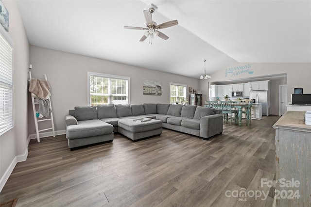 living room featuring hardwood / wood-style flooring, vaulted ceiling, and ceiling fan with notable chandelier