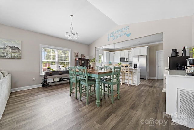 dining space featuring lofted ceiling, hardwood / wood-style floors, and a notable chandelier