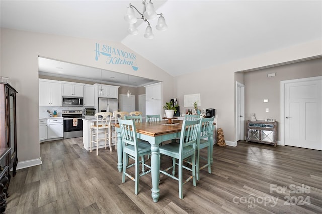 dining space featuring a notable chandelier, wood-type flooring, and vaulted ceiling