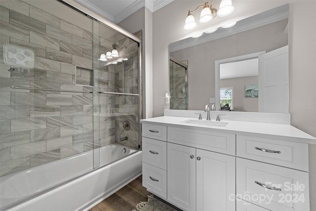 bathroom with hardwood / wood-style floors, combined bath / shower with glass door, vanity, and ornamental molding