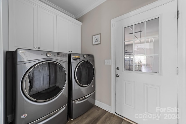 clothes washing area featuring crown molding, dark hardwood / wood-style floors, washing machine and clothes dryer, and cabinets