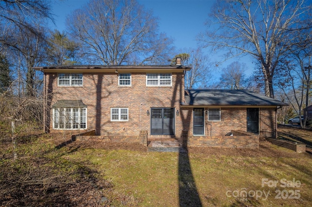 rear view of property with a lawn