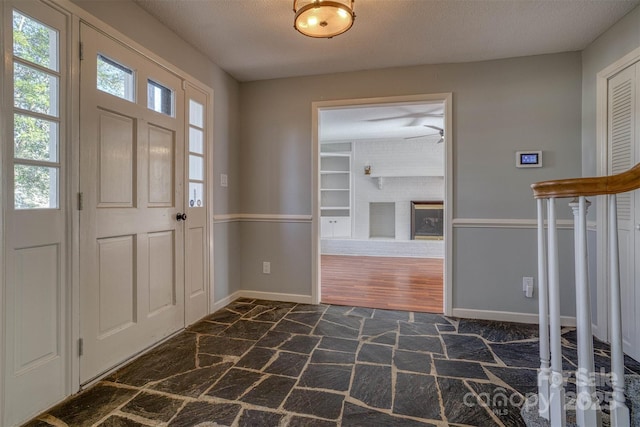 foyer with dark carpet and a textured ceiling