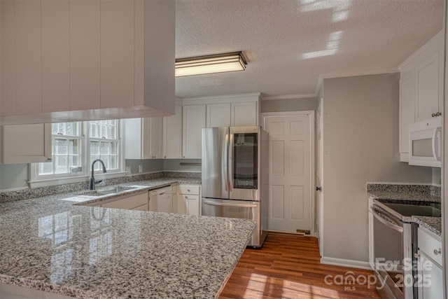 kitchen with light stone counters, sink, white cabinetry, and appliances with stainless steel finishes