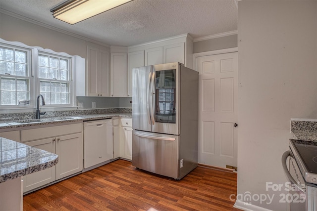 kitchen featuring dark hardwood / wood-style floors, sink, white cabinets, stainless steel appliances, and light stone countertops