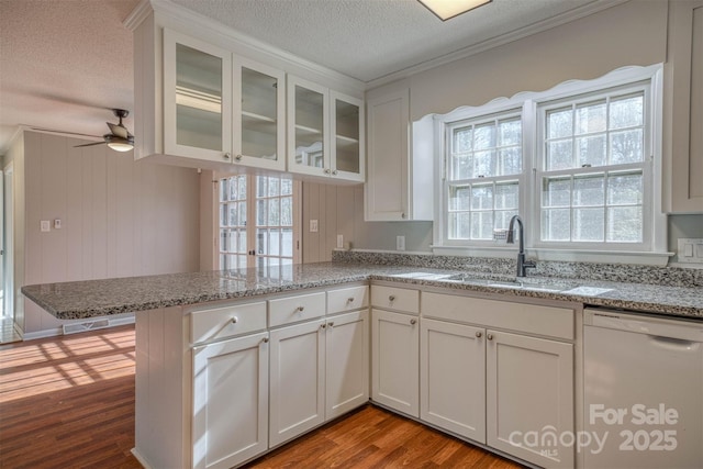 kitchen with white cabinets, light hardwood / wood-style flooring, kitchen peninsula, and dishwasher