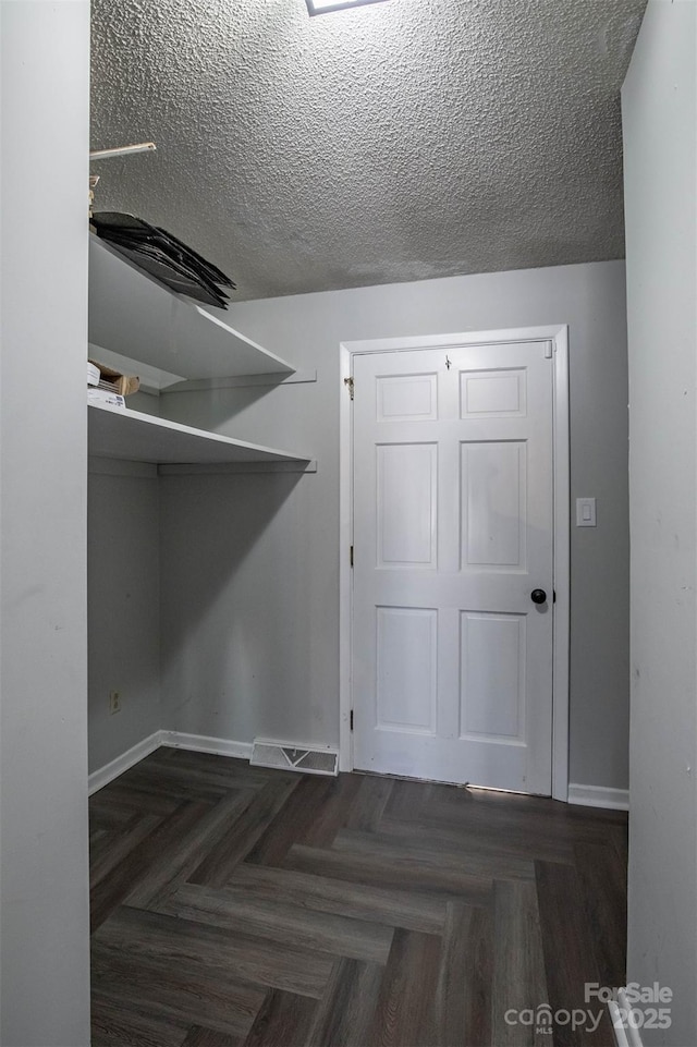 interior space featuring dark parquet floors and a textured ceiling