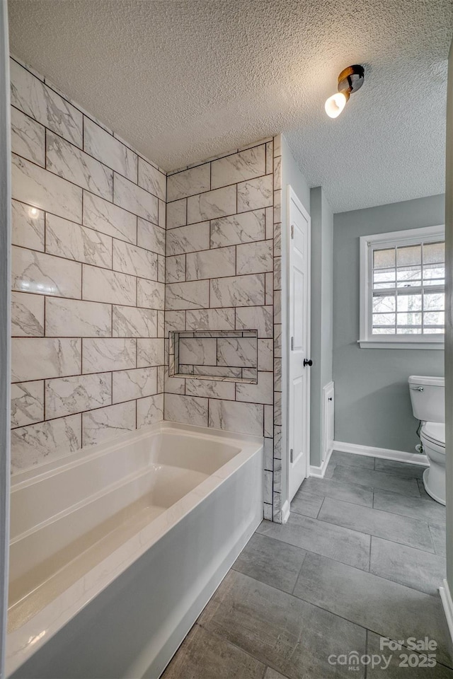 bathroom with a textured ceiling and toilet