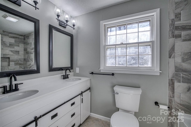 bathroom featuring vanity, tile patterned floors, toilet, and a textured ceiling