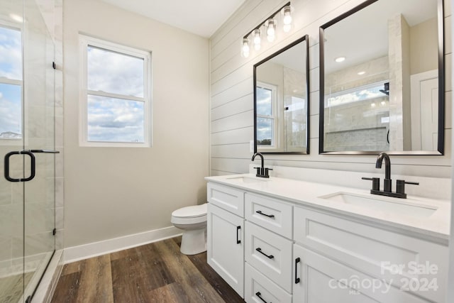 bathroom with a shower with door, vanity, wood-type flooring, and toilet