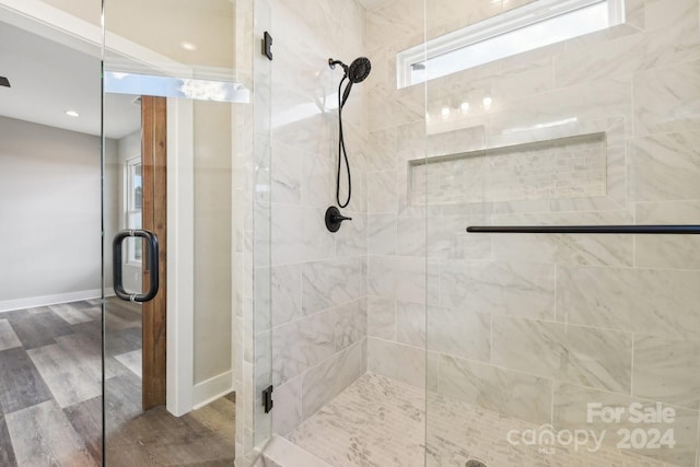 bathroom featuring wood-type flooring and an enclosed shower