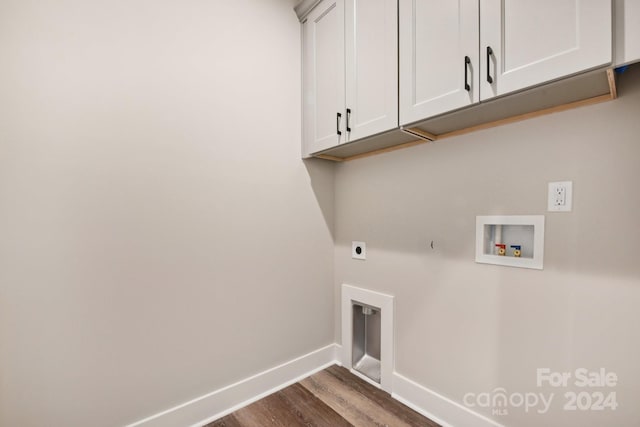 laundry area featuring electric dryer hookup, hookup for a washing machine, dark wood-type flooring, and cabinets