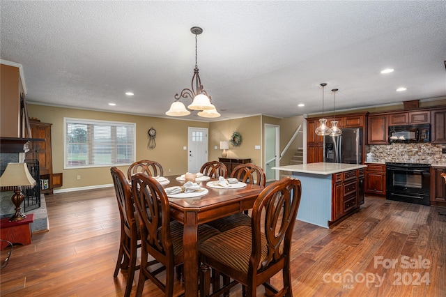 dining area with a textured ceiling, ornamental molding, dark hardwood / wood-style floors, and a notable chandelier