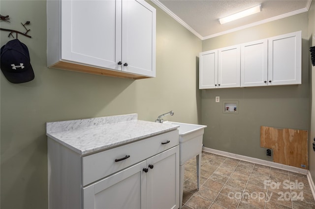 laundry room with a textured ceiling, ornamental molding, washer hookup, and cabinets