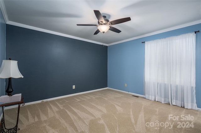 empty room with ornamental molding, light carpet, and ceiling fan