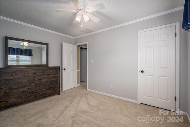 unfurnished bedroom featuring a textured ceiling, ornamental molding, ceiling fan, and light colored carpet