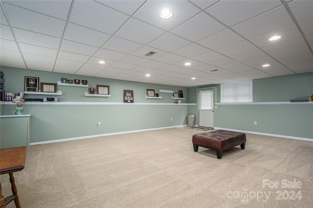 sitting room featuring light carpet and a paneled ceiling