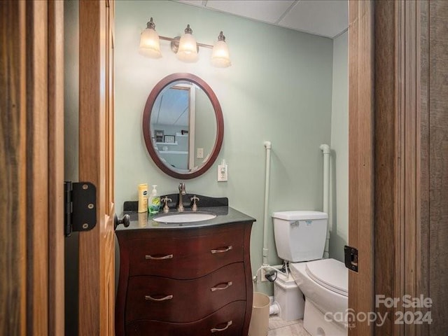 bathroom featuring tile patterned flooring, vanity, and toilet