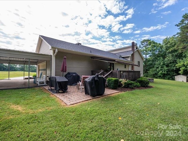 back of house featuring a lawn, a storage shed, a patio area, and a deck