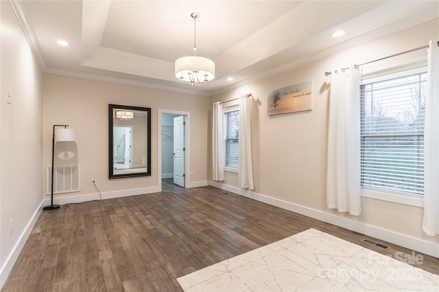 entrance foyer featuring crown molding, a tray ceiling, dark hardwood / wood-style flooring, and a notable chandelier