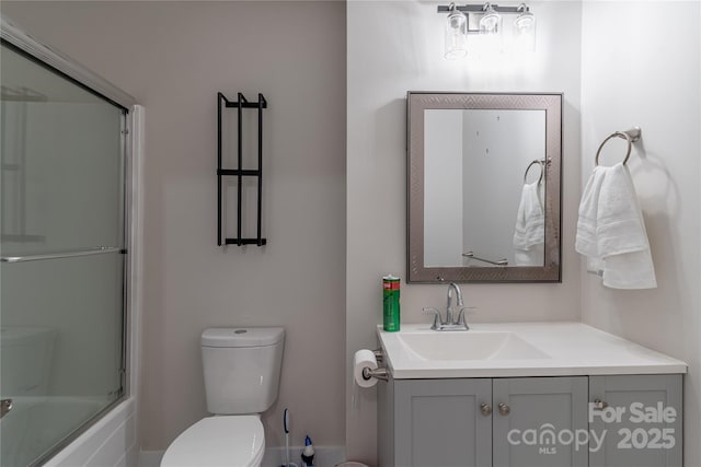 full bathroom featuring vanity, shower / bath combination with glass door, and toilet