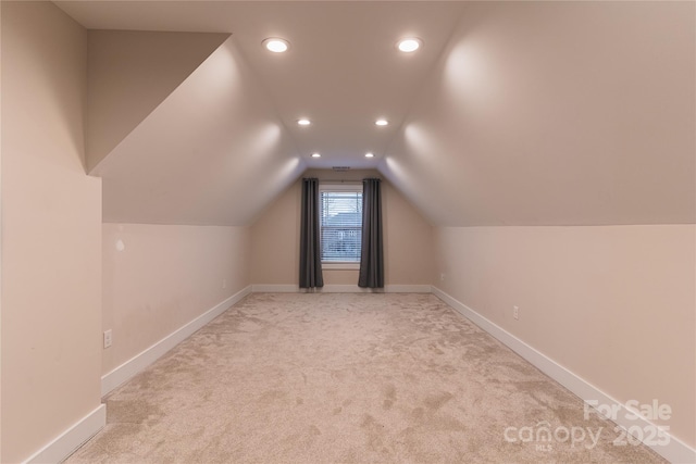 additional living space with vaulted ceiling and light colored carpet