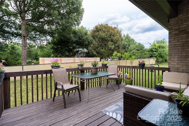 deck with an outdoor living space and a yard