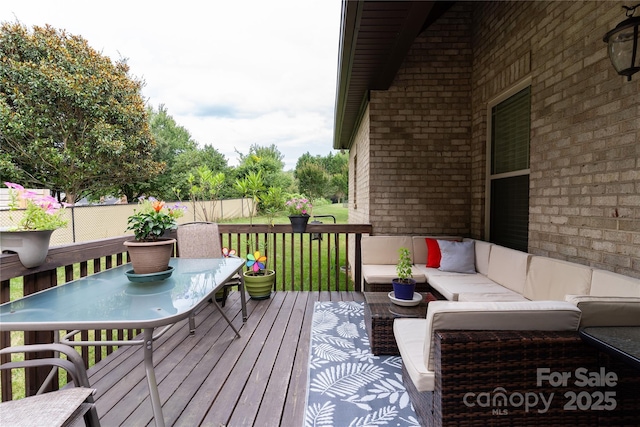 wooden deck with a lawn and outdoor lounge area