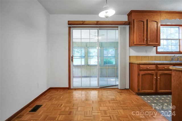 kitchen with sink, hanging light fixtures, and light parquet floors