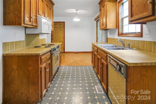 kitchen with dark parquet floors, sink, white appliances, and decorative light fixtures