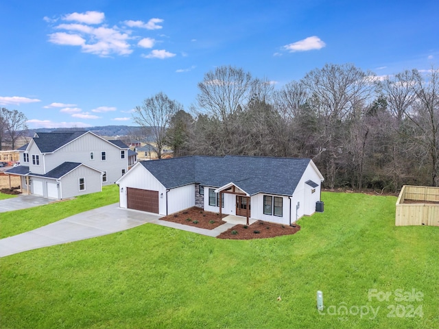 view of front of house featuring a garage and a front lawn