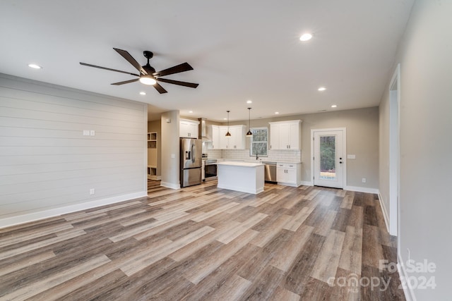 unfurnished living room featuring ceiling fan, sink, and light hardwood / wood-style floors