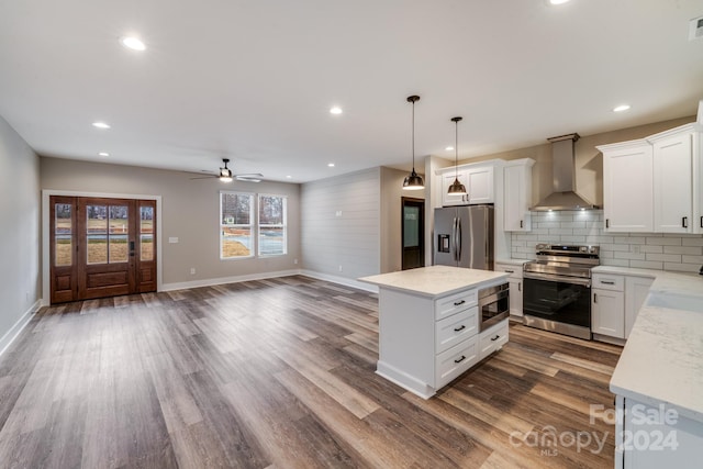 kitchen with white cabinetry, wall chimney range hood, and appliances with stainless steel finishes