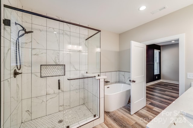 bathroom with separate shower and tub and hardwood / wood-style floors