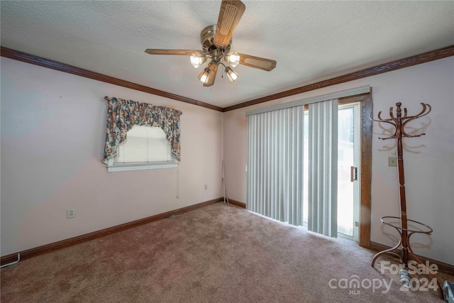 empty room with ornamental molding, carpet flooring, a wealth of natural light, and a textured ceiling