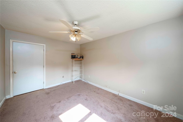 unfurnished bedroom with ceiling fan, a textured ceiling, and carpet