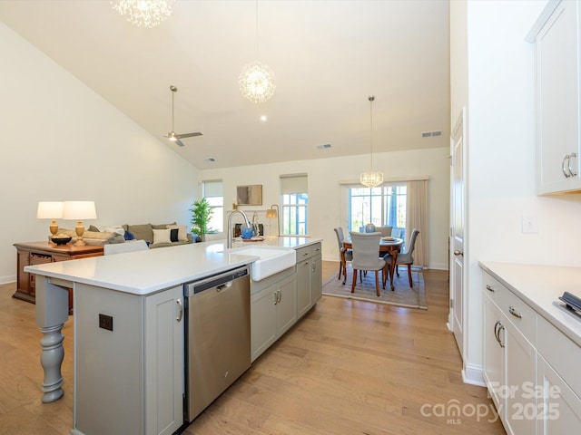 kitchen with pendant lighting, sink, stainless steel dishwasher, and an island with sink