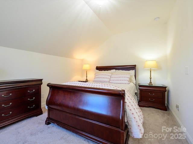 bedroom with light colored carpet and vaulted ceiling