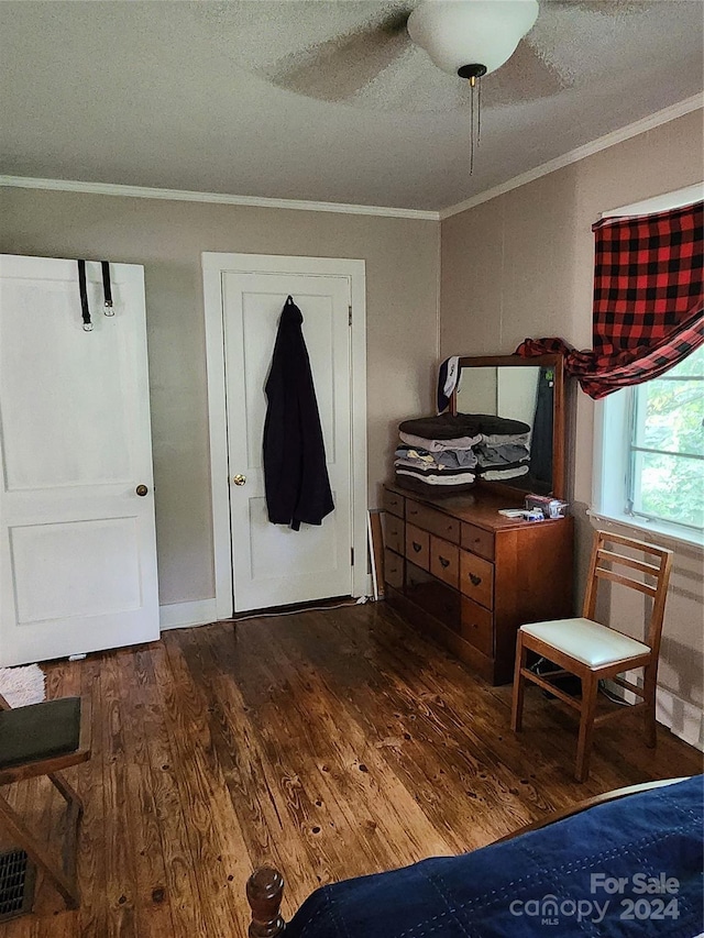 bedroom with dark wood-type flooring, ceiling fan, and crown molding