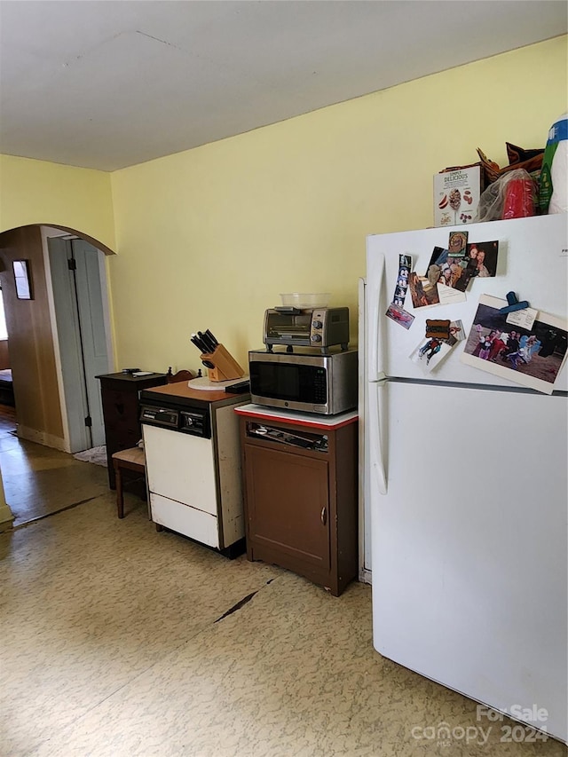 kitchen featuring dark brown cabinetry and white appliances