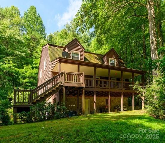 rear view of property with a deck and a lawn