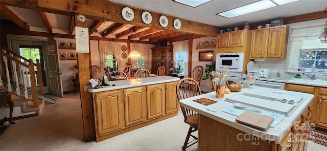 kitchen with dishwasher, a center island, light colored carpet, and sink