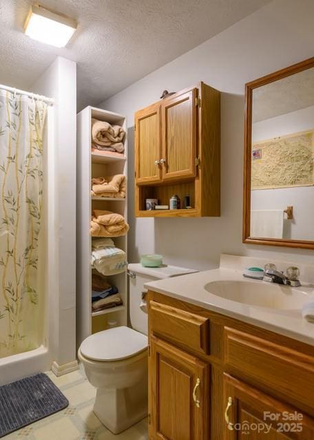 bathroom with vanity, curtained shower, toilet, and a textured ceiling