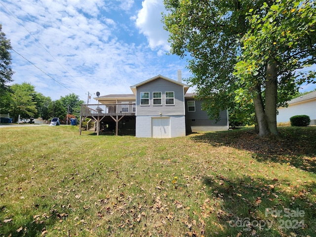 rear view of property featuring a yard and a wooden deck