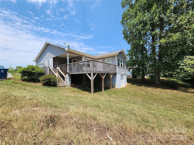 rear view of property featuring a deck and a yard