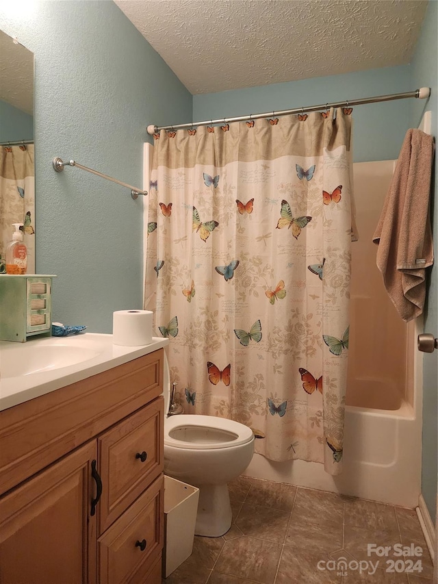 full bathroom with toilet, vanity, shower / bath combo with shower curtain, and a textured ceiling