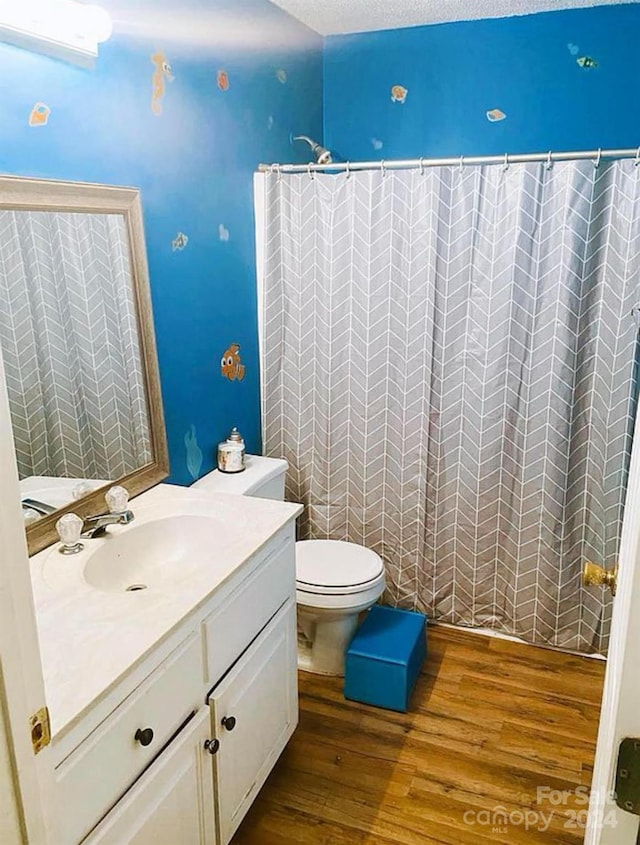 bathroom featuring hardwood / wood-style flooring, a textured ceiling, toilet, and vanity